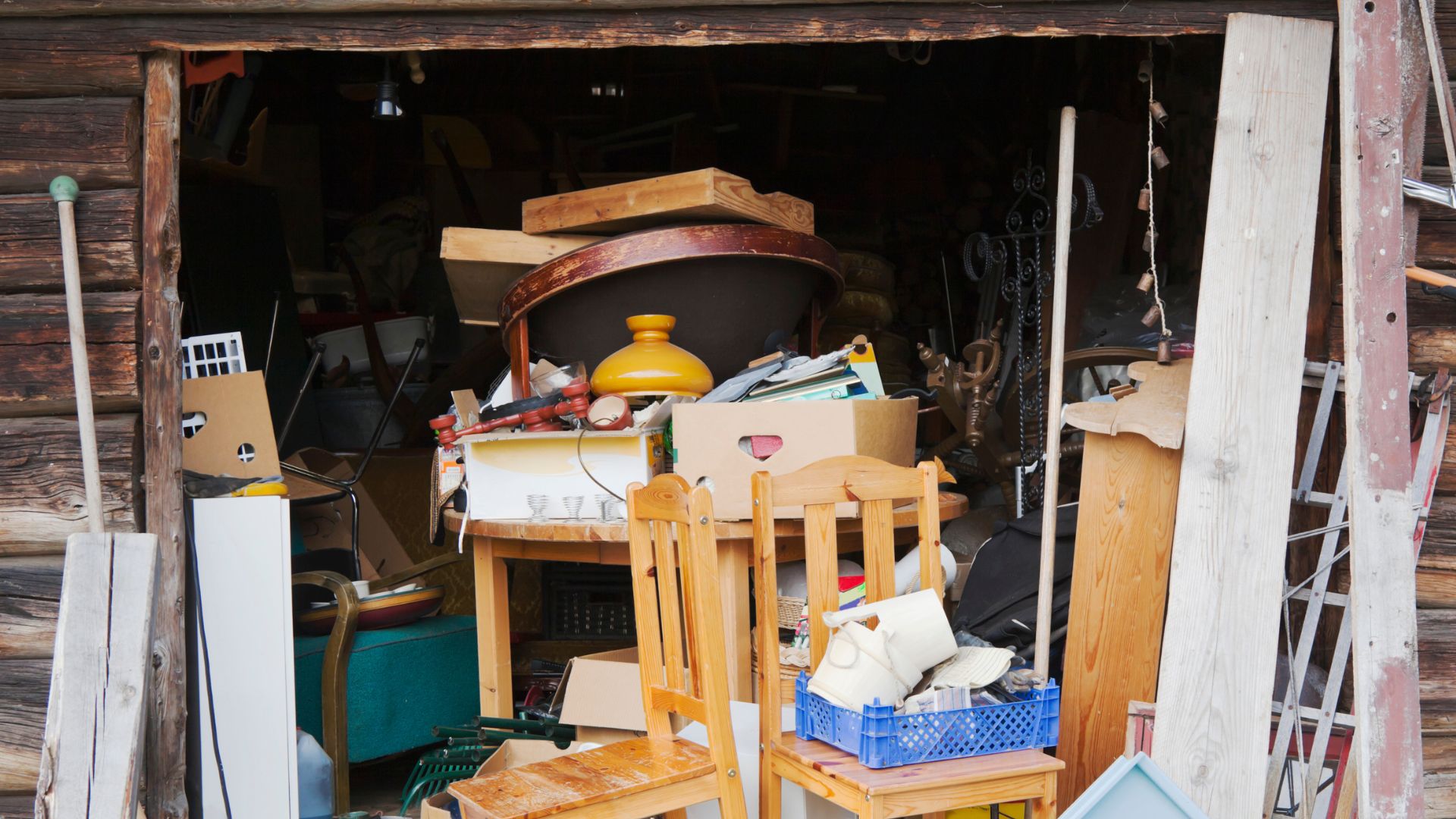 A pile of furniture sitting inside of a wooden shed