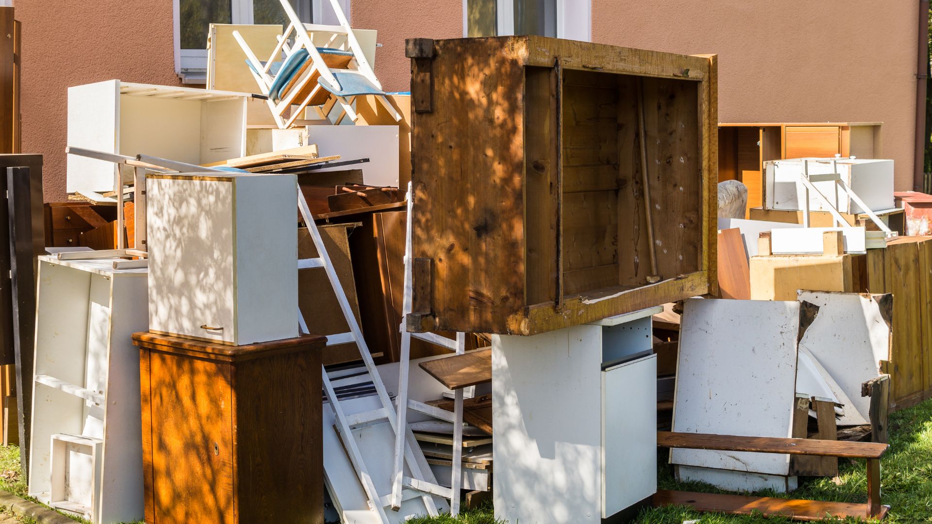 A pile of old refrigerators sitting outside of a building